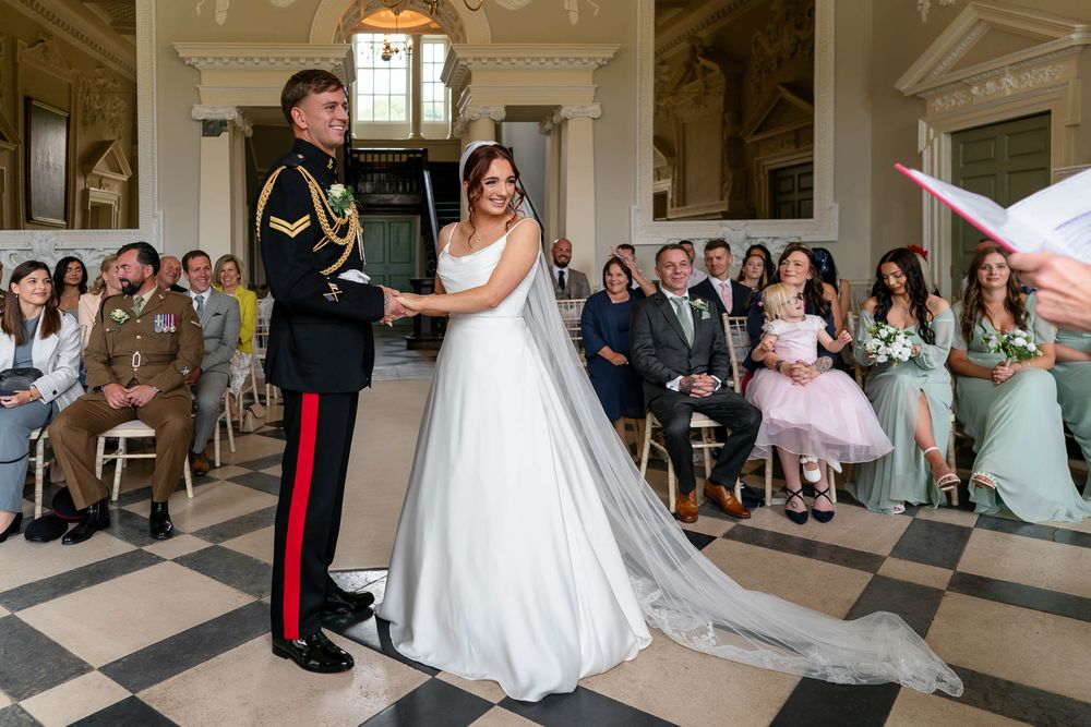 Bride and Groom in military uniform holding hands during their Somerset Wedding at Crowcombe Court.