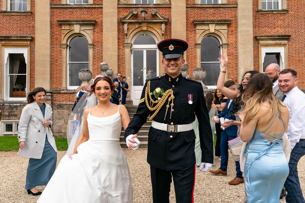 Bride and Groom walking through confetti at Crowcombe Court