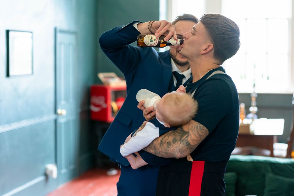 Military Groom holding baby and drinking at Crowcombe Court