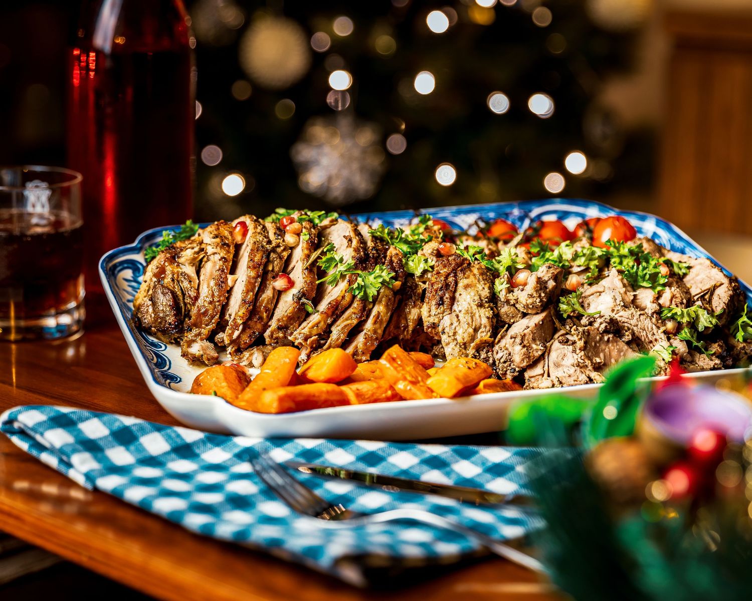 Grilled chicken slices arranged on platter with roasted carrots and fresh herbs for dinner service.