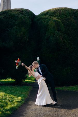 Bride and groom share a romantic dip kiss in Painswick captured by a Cotswolds wedding photographer.