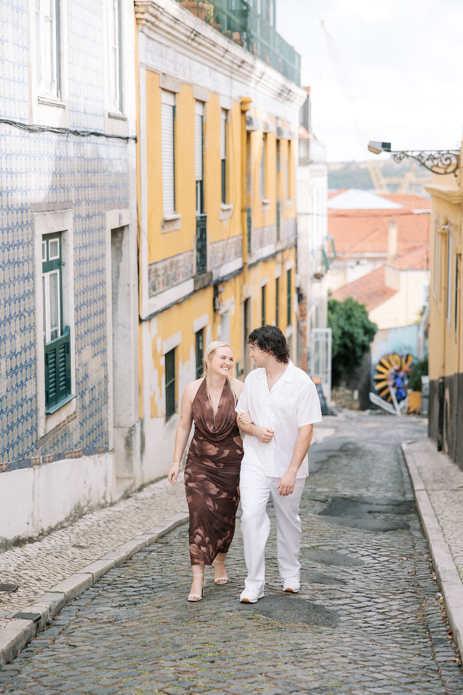 Destination wedding couple walking through historic Lisbon streets in portugal
