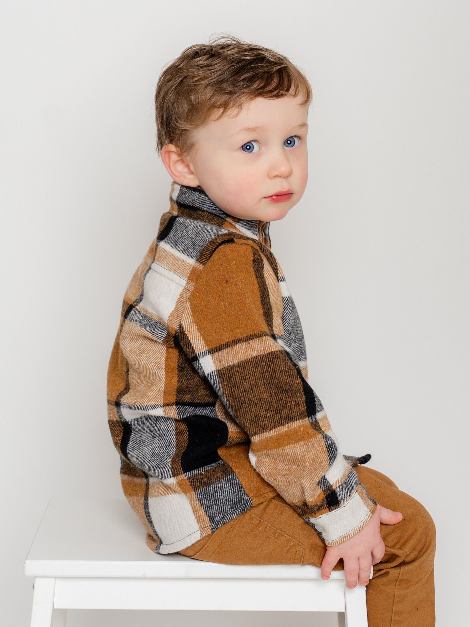 Portrait of a little boy sitting on a stool in Dandridge TN family photographer's studio.