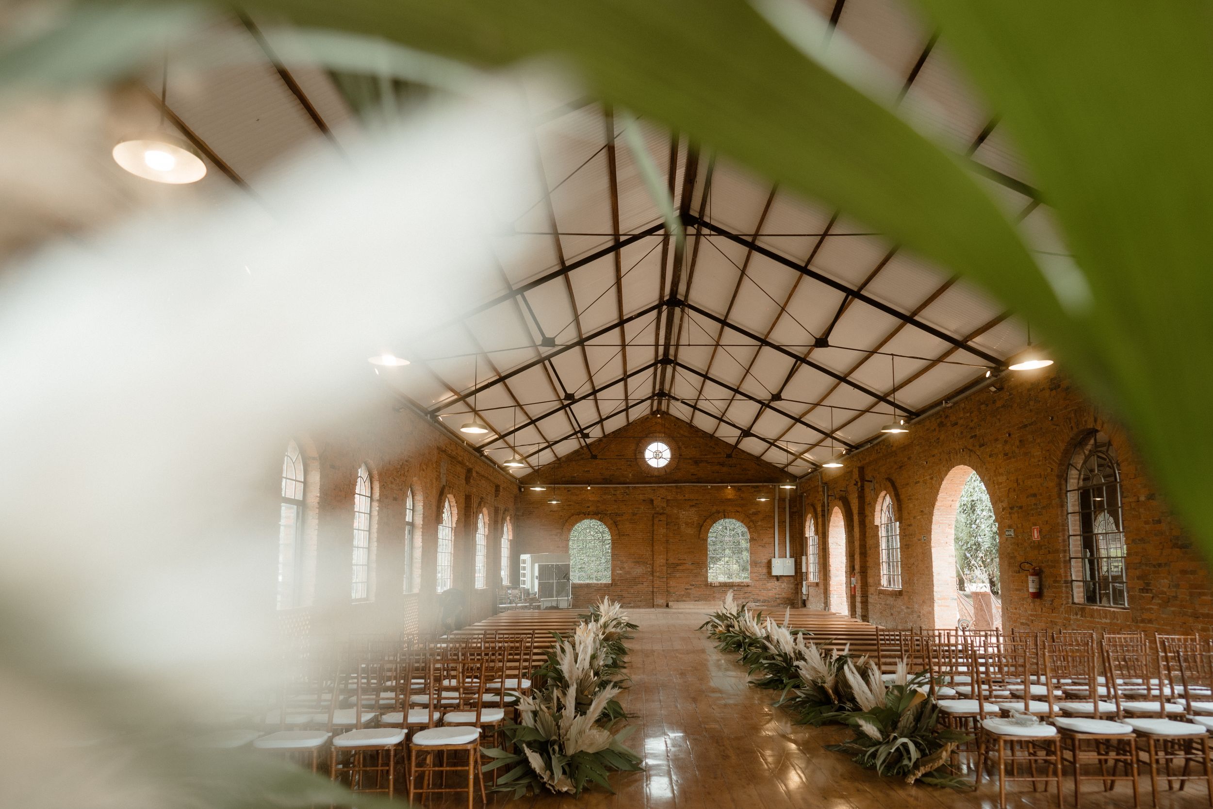 Sun-filled brick chapel with exposed beams and rows of chairs set for a ceremony.