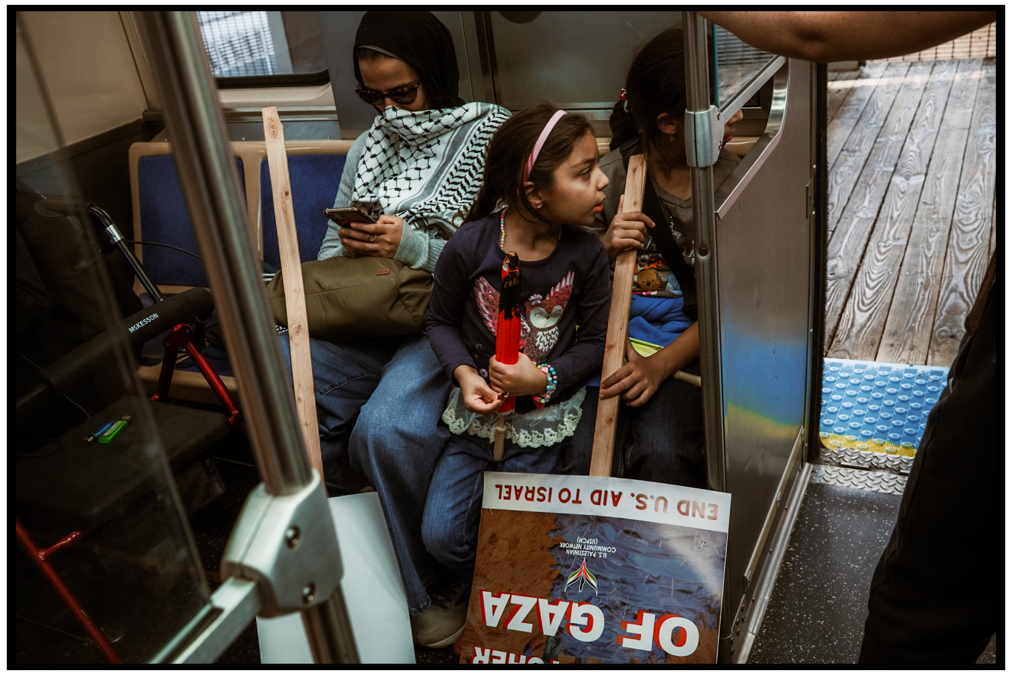 Passengers ride inside a subway car with protest signs and flags. Chicago. March on DNC