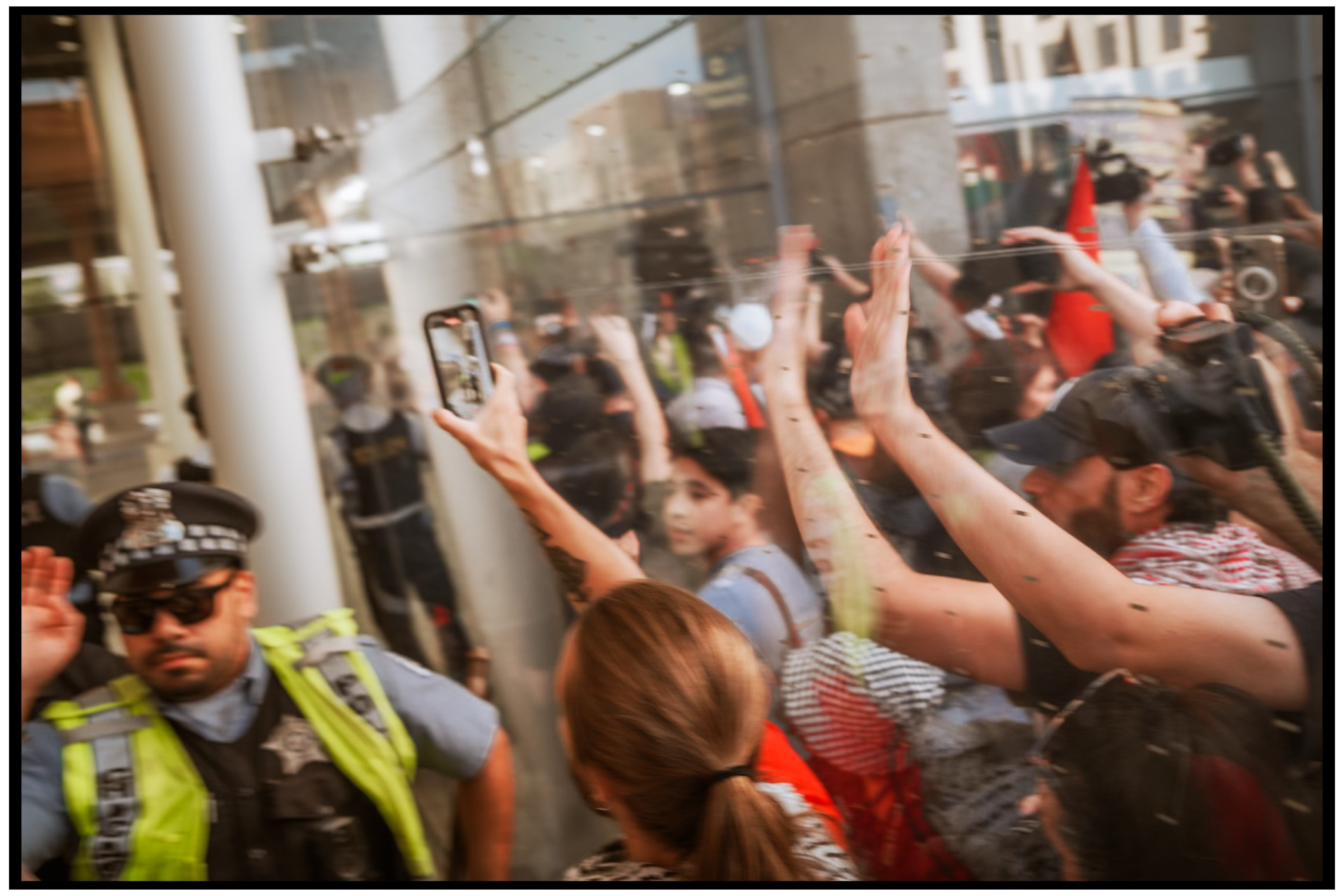 Crowd of demonstrators with raised hands and phones during protest. Chicago. March on DNC