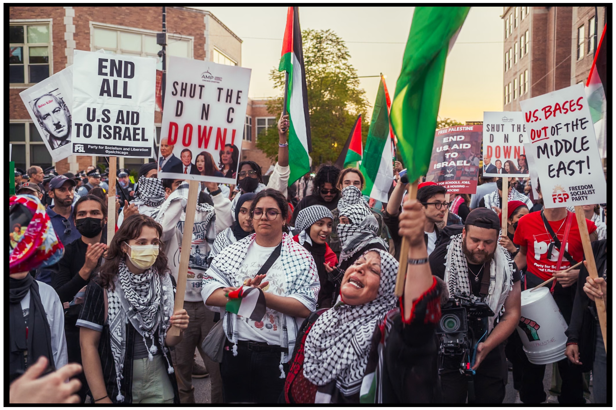 Protesters hold signs and Palestinian flags during street demonstration. Chicago. March on DNC