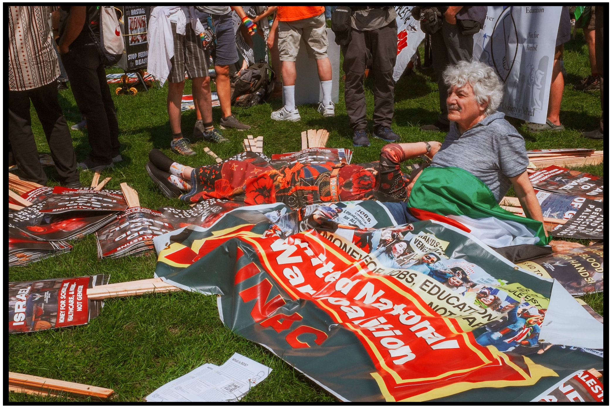Protest signs and banners lay scattered on grass during demonstration. Chicago. March on DNC