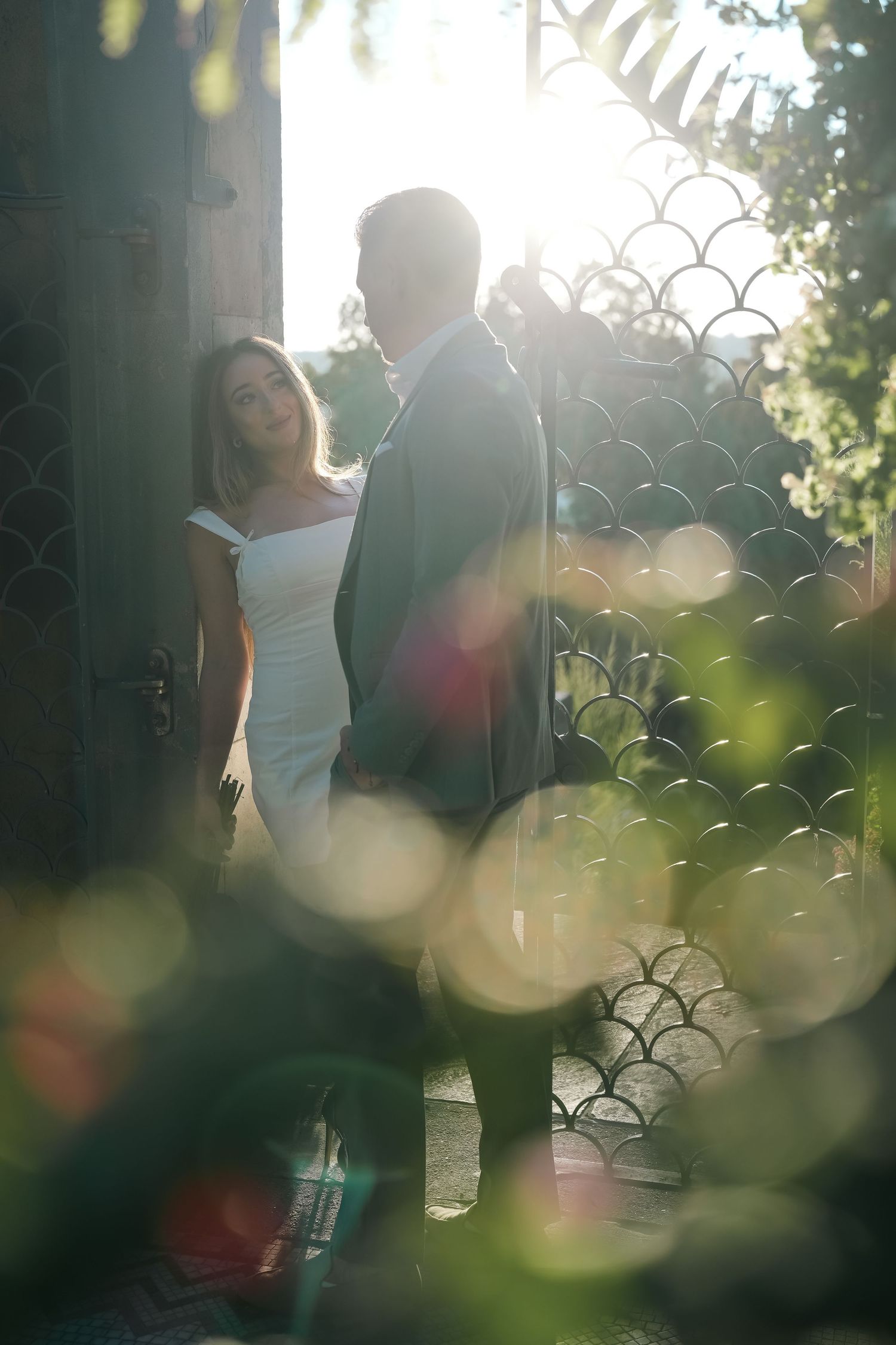 Artistic outdoor photoshoot with dreamy bokeh effects and natural sunlight filtering through trees.
