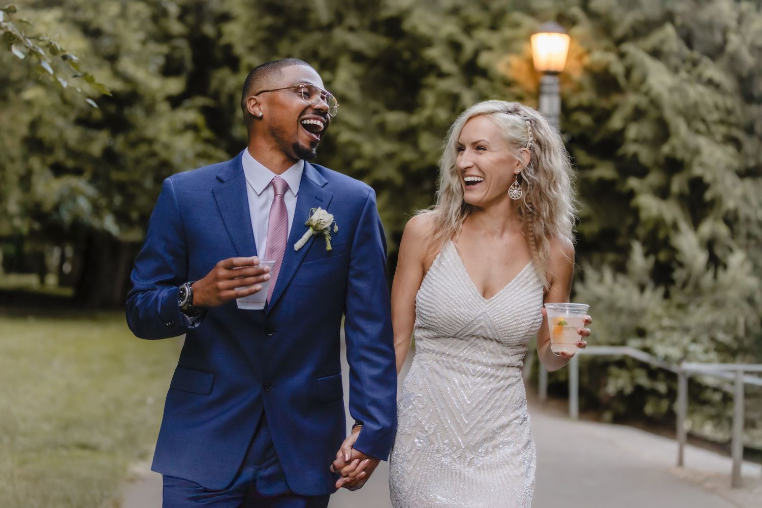 A joyful couple laughs together during their outdoor wedding celebration.