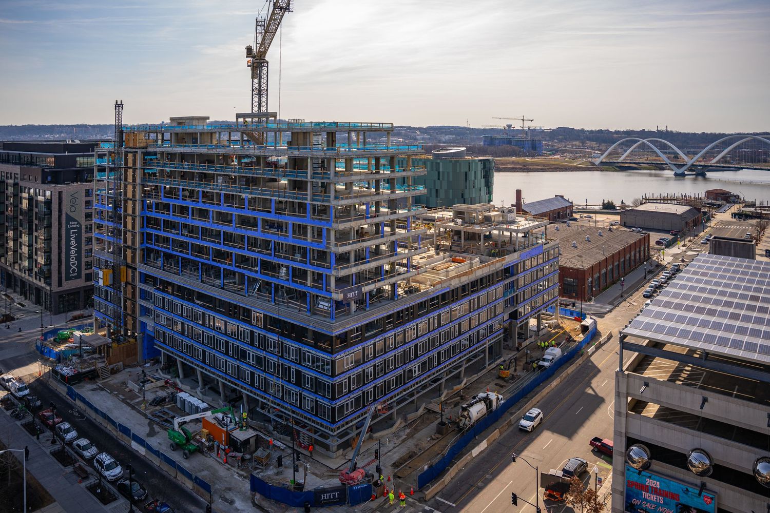 Construction site showing a multi-story building under development with a crane and scaffolding against an urban skyline.