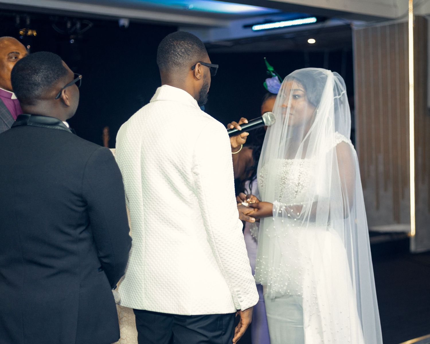 A couple exchanges vows during their wedding ceremony in an indoor venue.