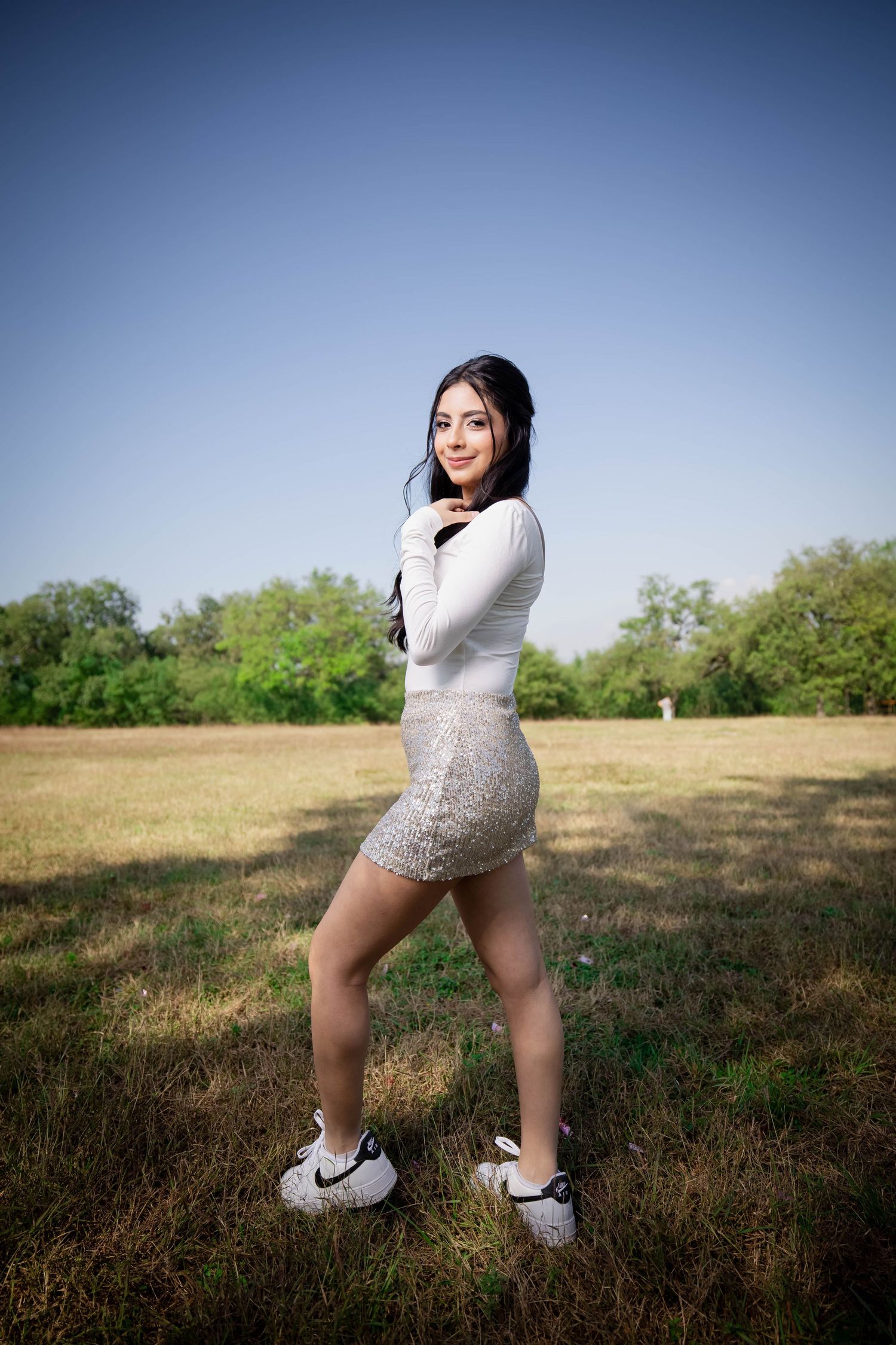 A casual outdoor portrait taken in a grassy field against a blue sky.