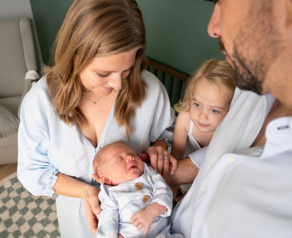 Intimate family moments with newborn baby in soft lighting.
