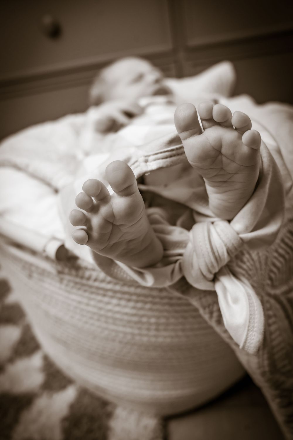Black and white series of tiny baby feet against soft textures.
