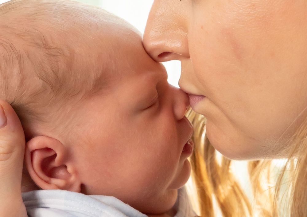 Intimate close-up of tender bonding moment with newborn.