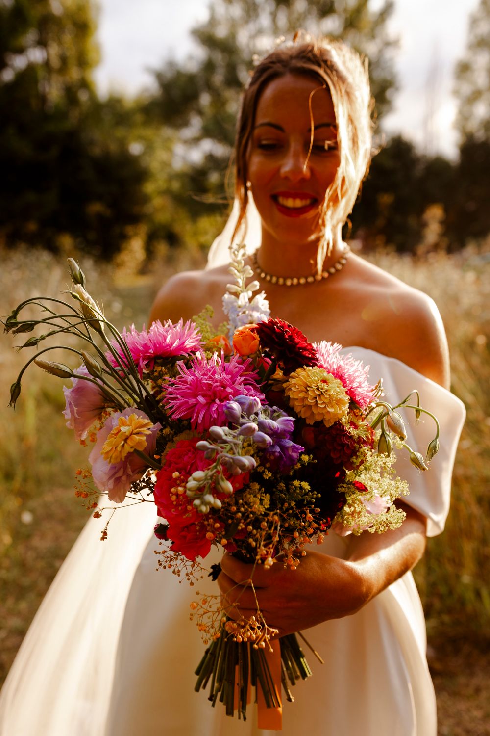 Mariée et son bouquet coloré au coucher du soleil