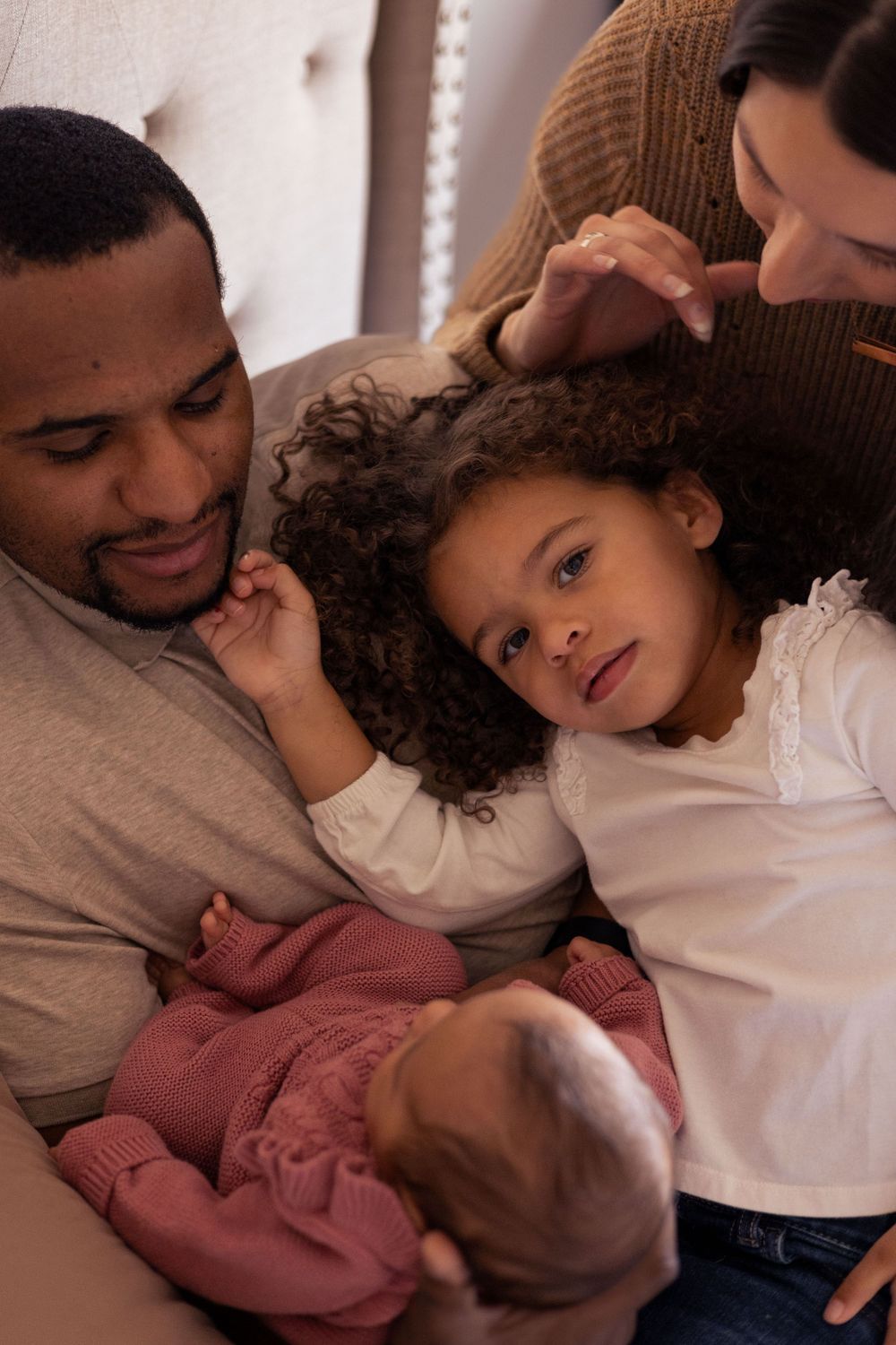 A family looks lovingly at their newborn.