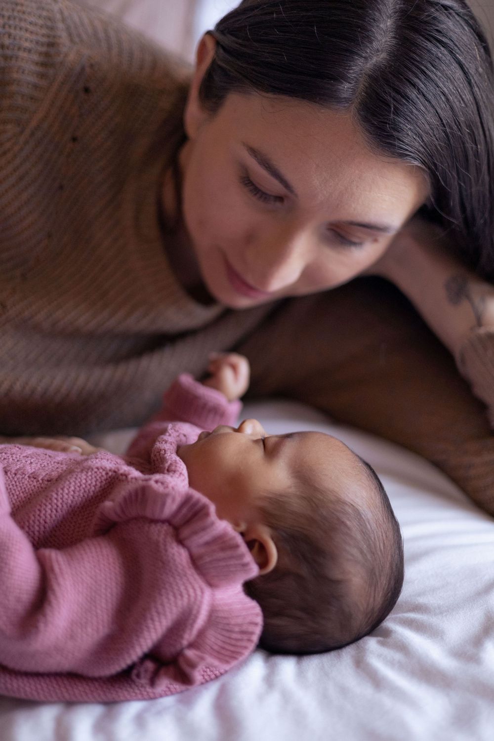 A mom watches her newborn sleep.