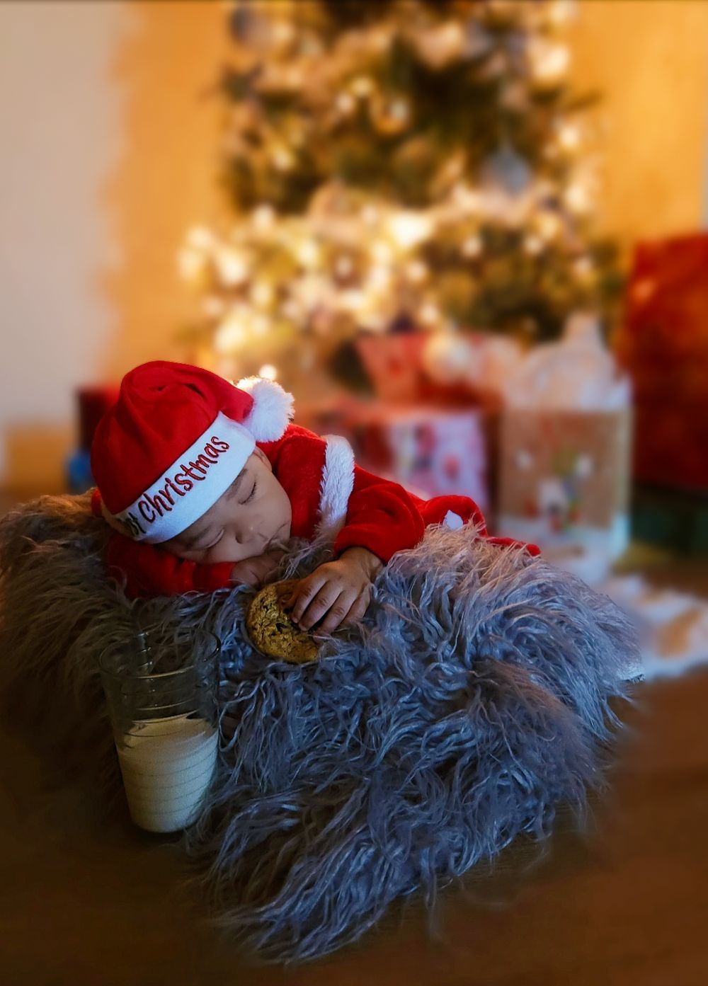 Infant photoshoot for Christmas in baby Santa outfit.