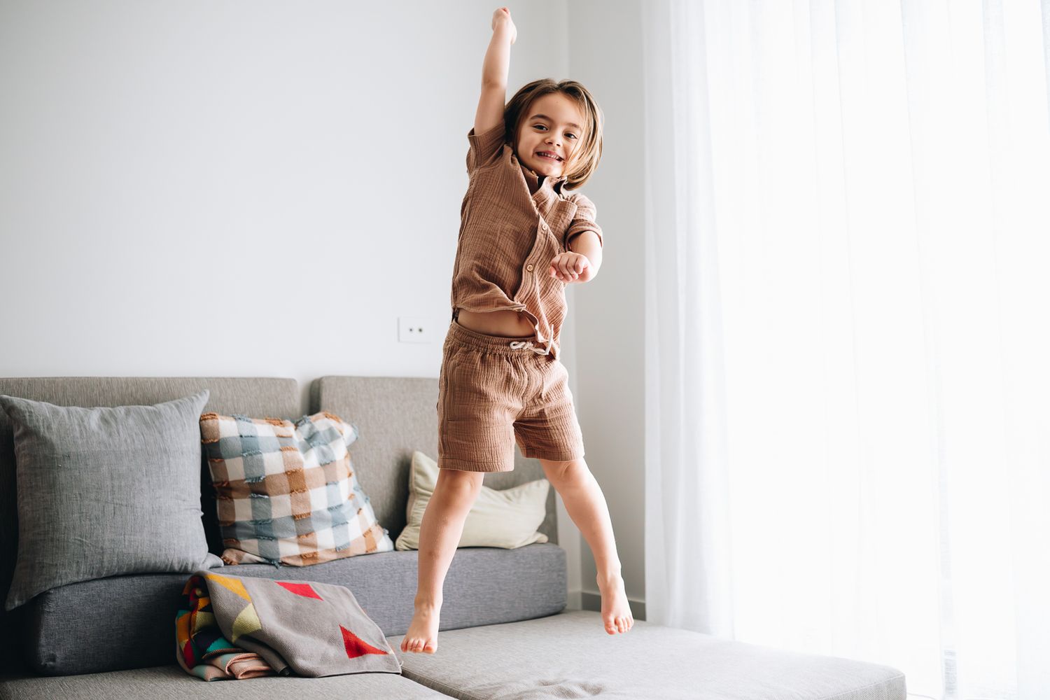 Elder brother jumping with joy during a newborn and family photoshoot at home by Melbourne newborn and family photographer Pei A Photography