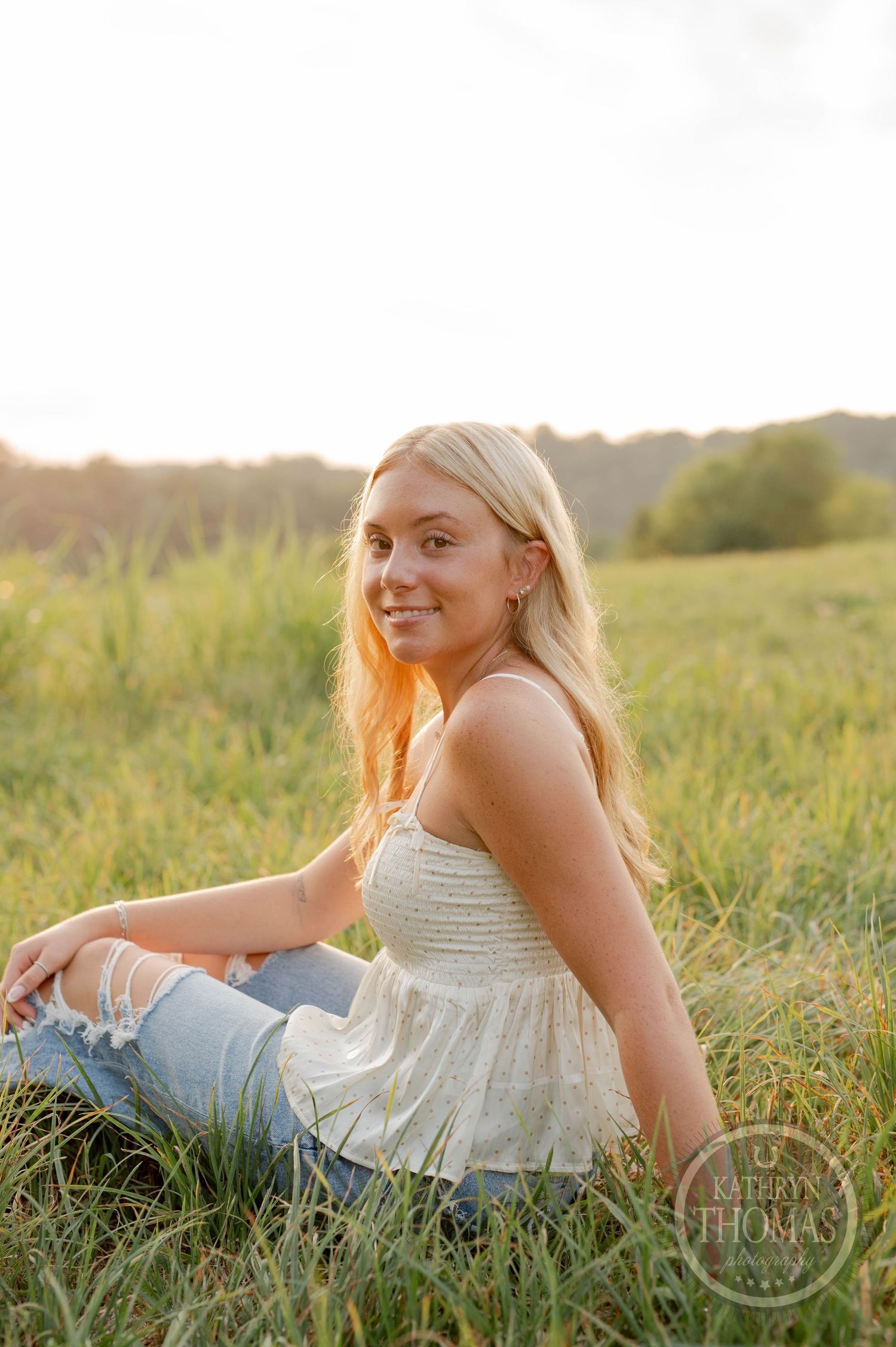 Golden hour portrait in tall grass meadow with warm lighting.