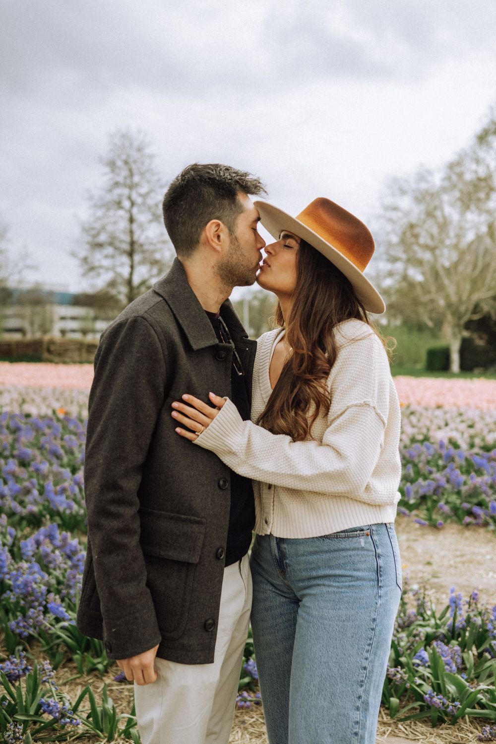 Romantic moment between couple in a flower field with purple blooms.