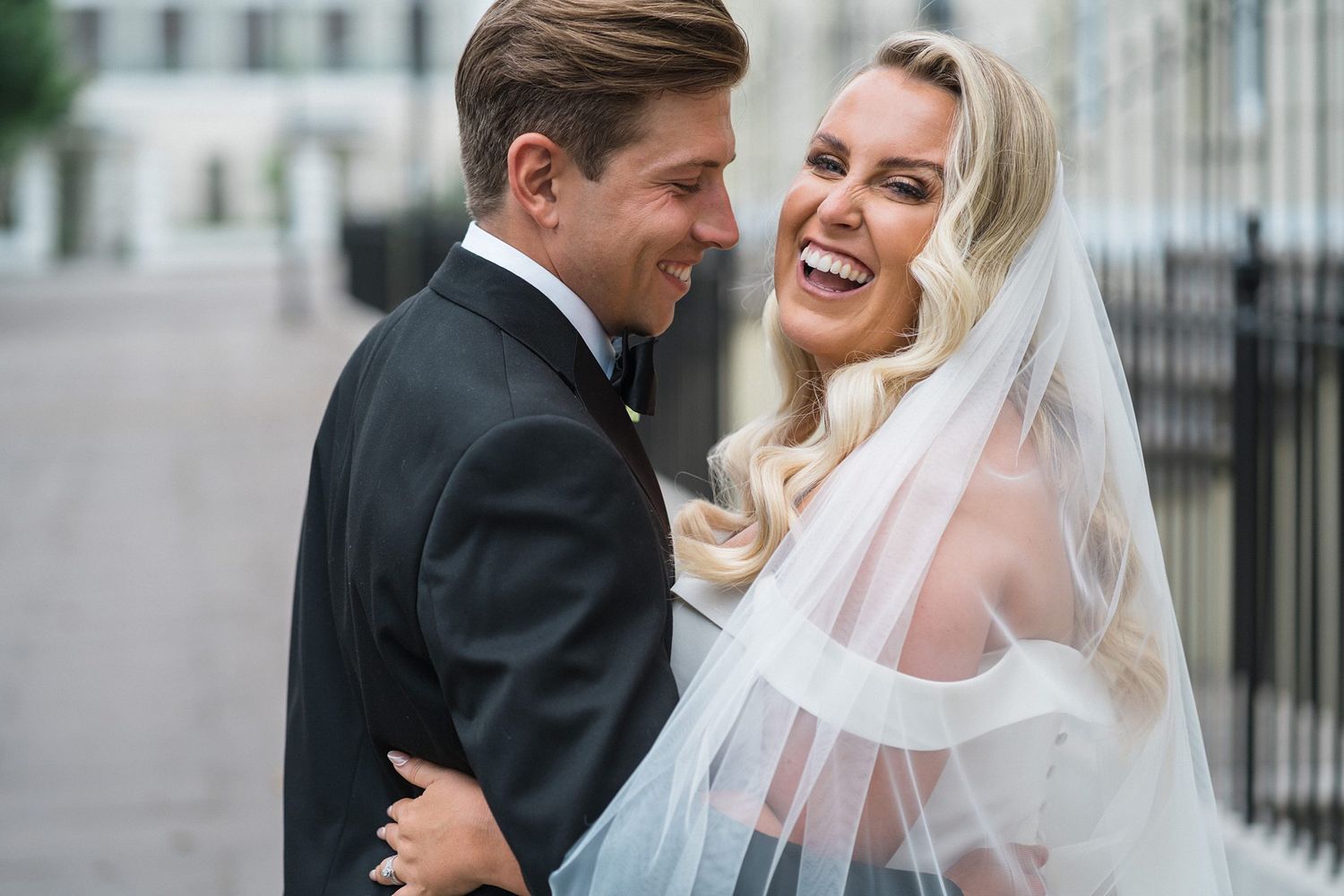 Happy couple in wedding attire share a joyful moment together outdoors on their special day for Nova Scotia wedding photographer.