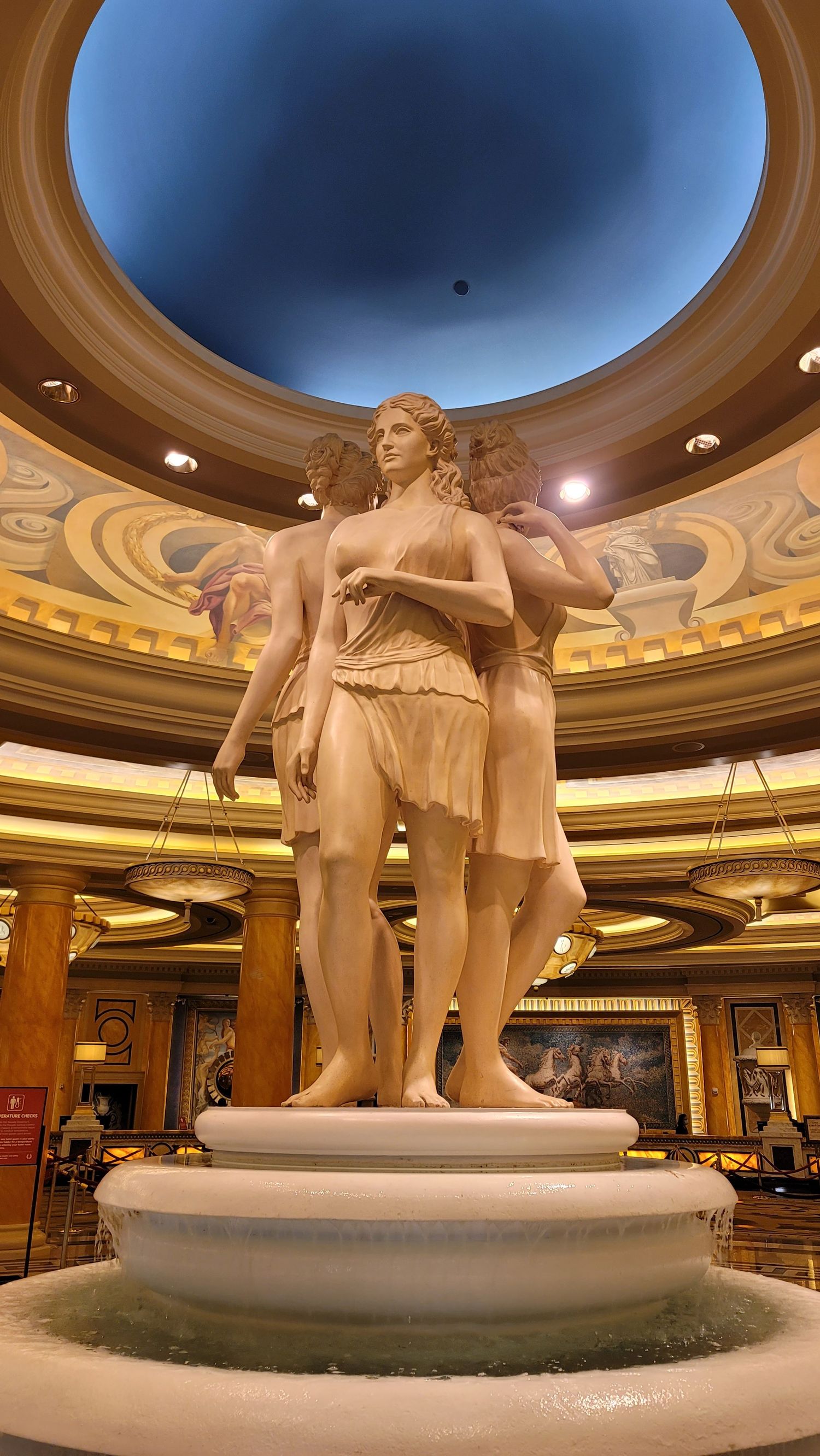 Elegant marble statue inside a Las Vegas casino, photographed beneath a domed ceiling on a smartphone.