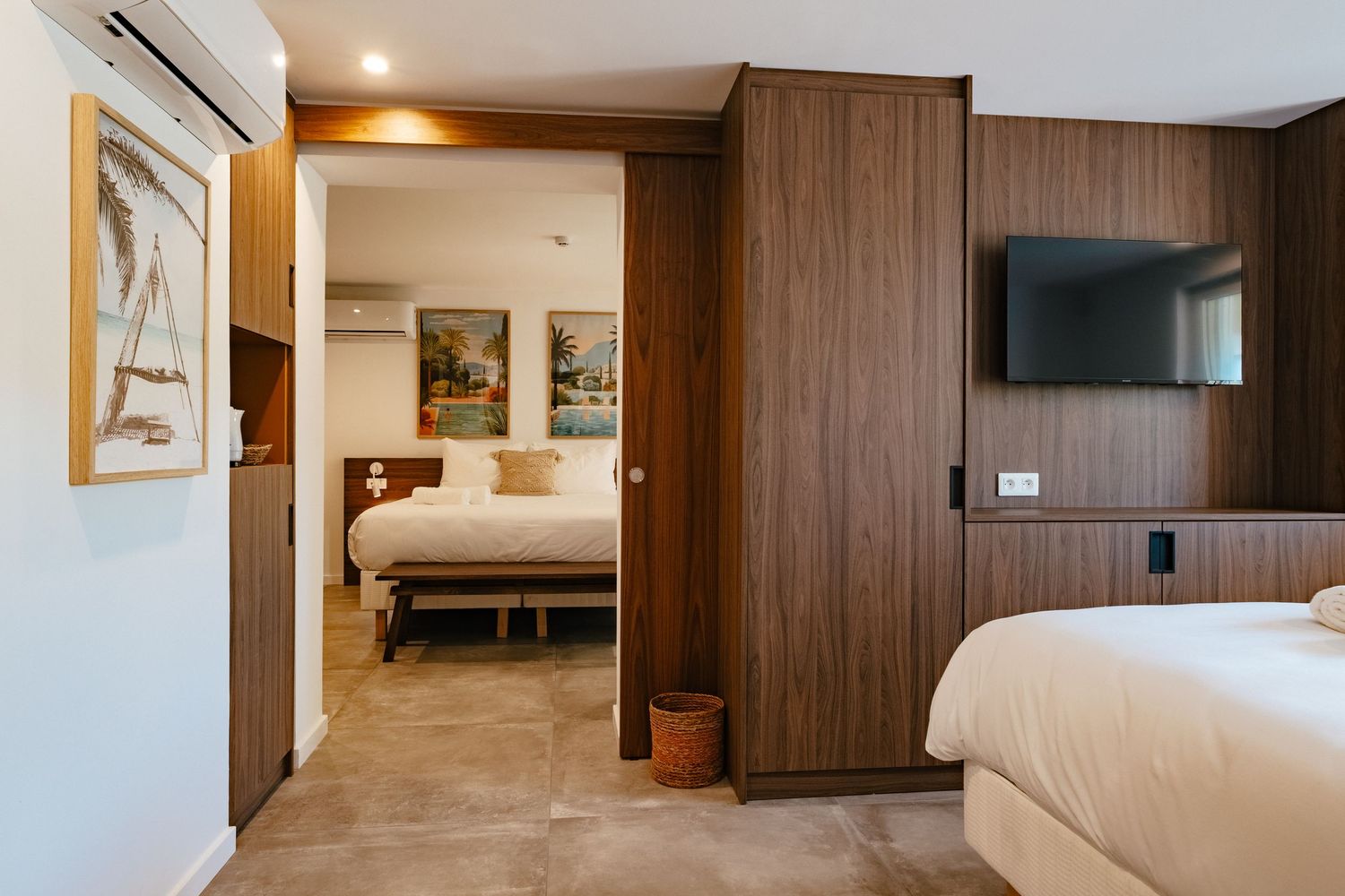 Luxurious hotel suite with wooden paneled walls, connecting rooms, and modern furnishings.