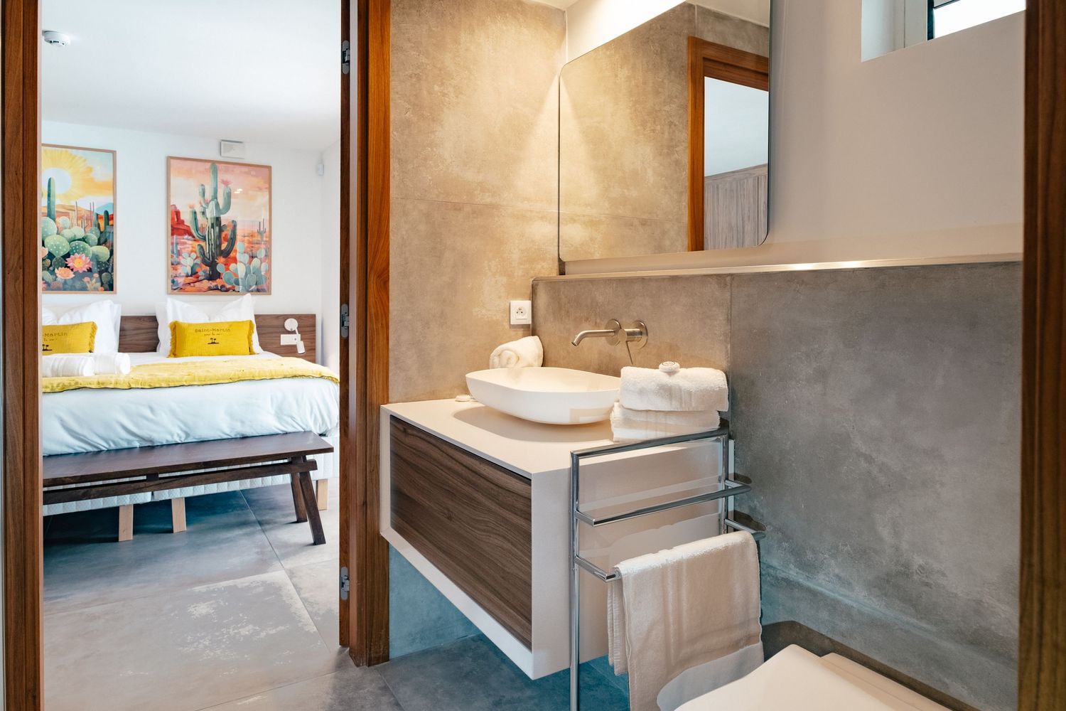 Contemporary bathroom connecting to bedroom with floating vanity, vessel sink and grey stone walls.