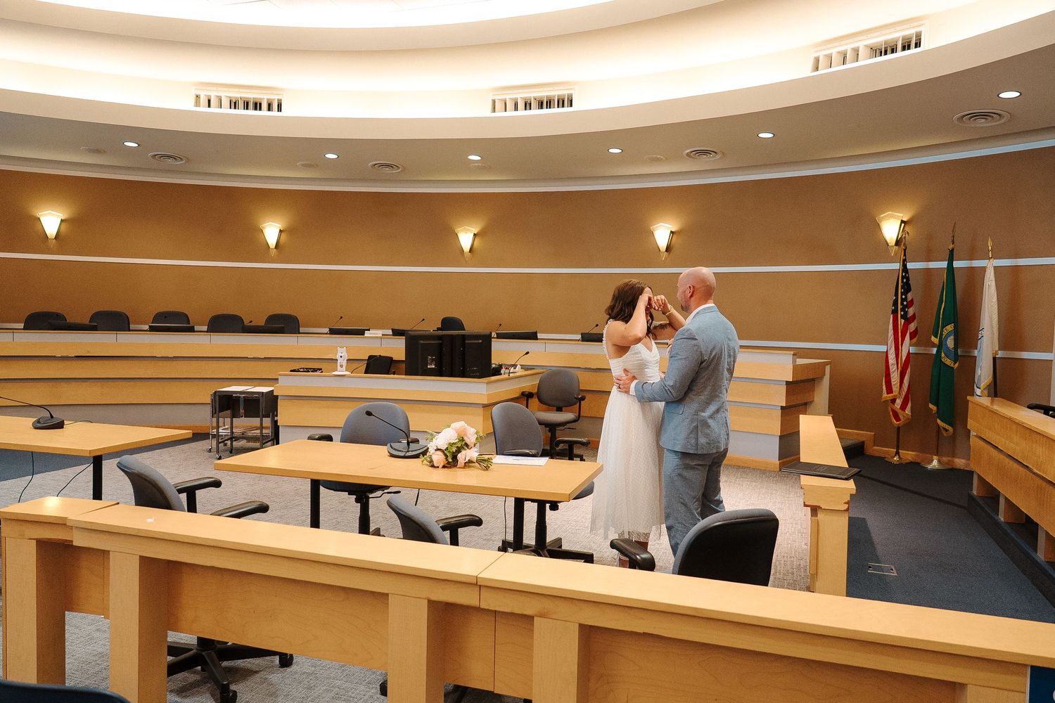 A modern courtroom interior with tiered seating, wood paneling, and recessed lighting in the ceiling.