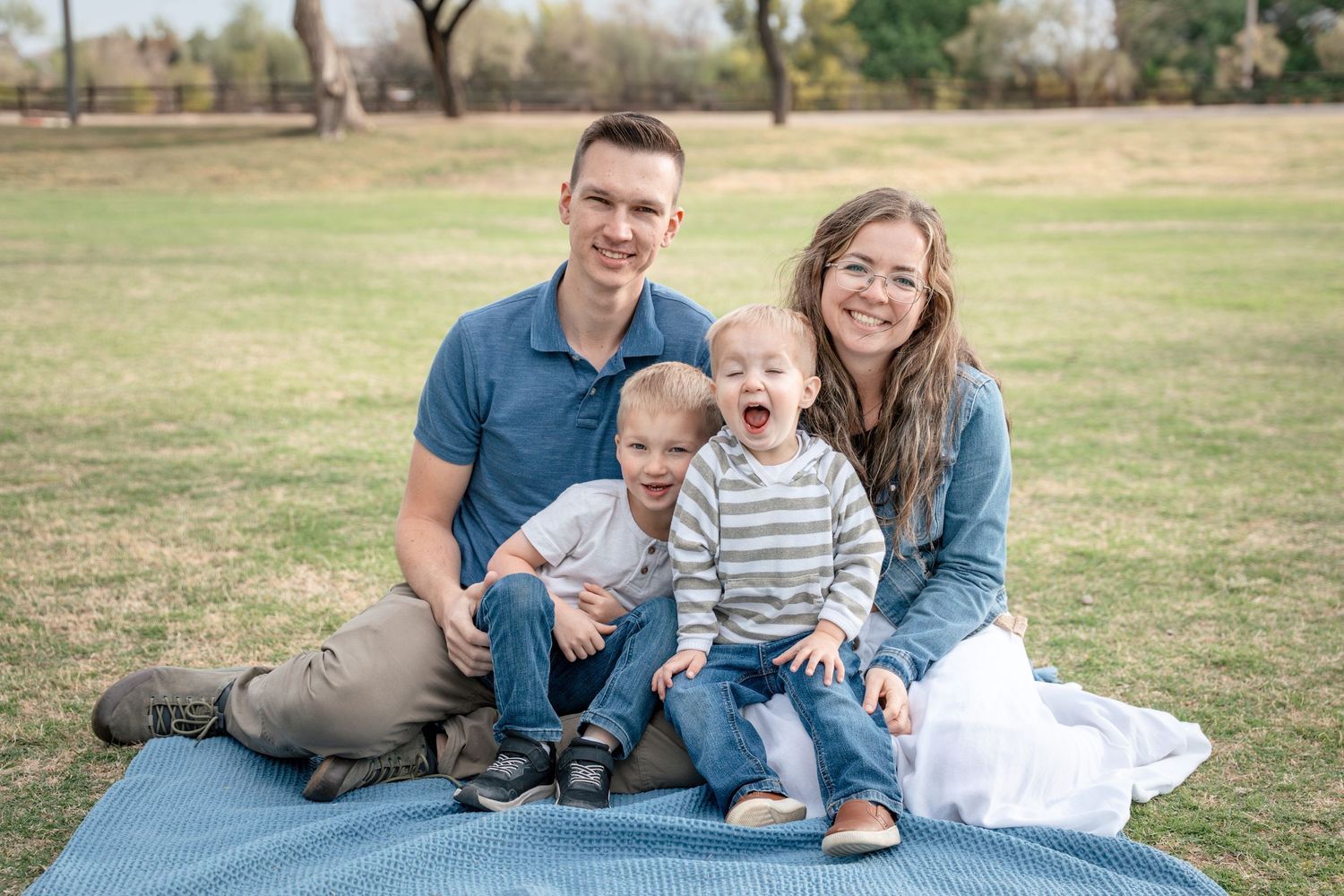 Des Moines Iowa family portrait of a young couple with their children sitting on a blanket.