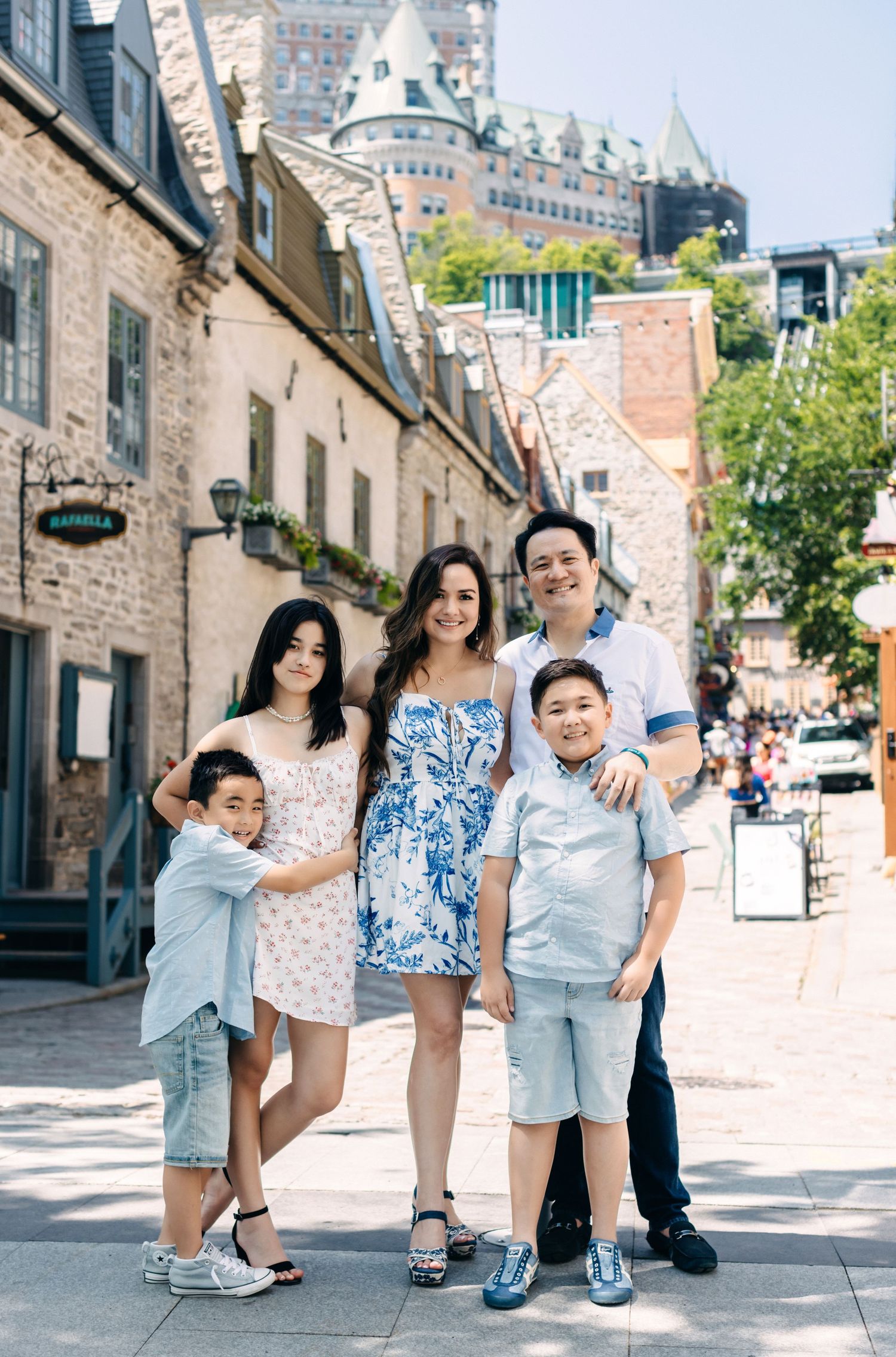 Charming cobblestone street in Quebec City with historic Chateau Frontenac castle visible in background.