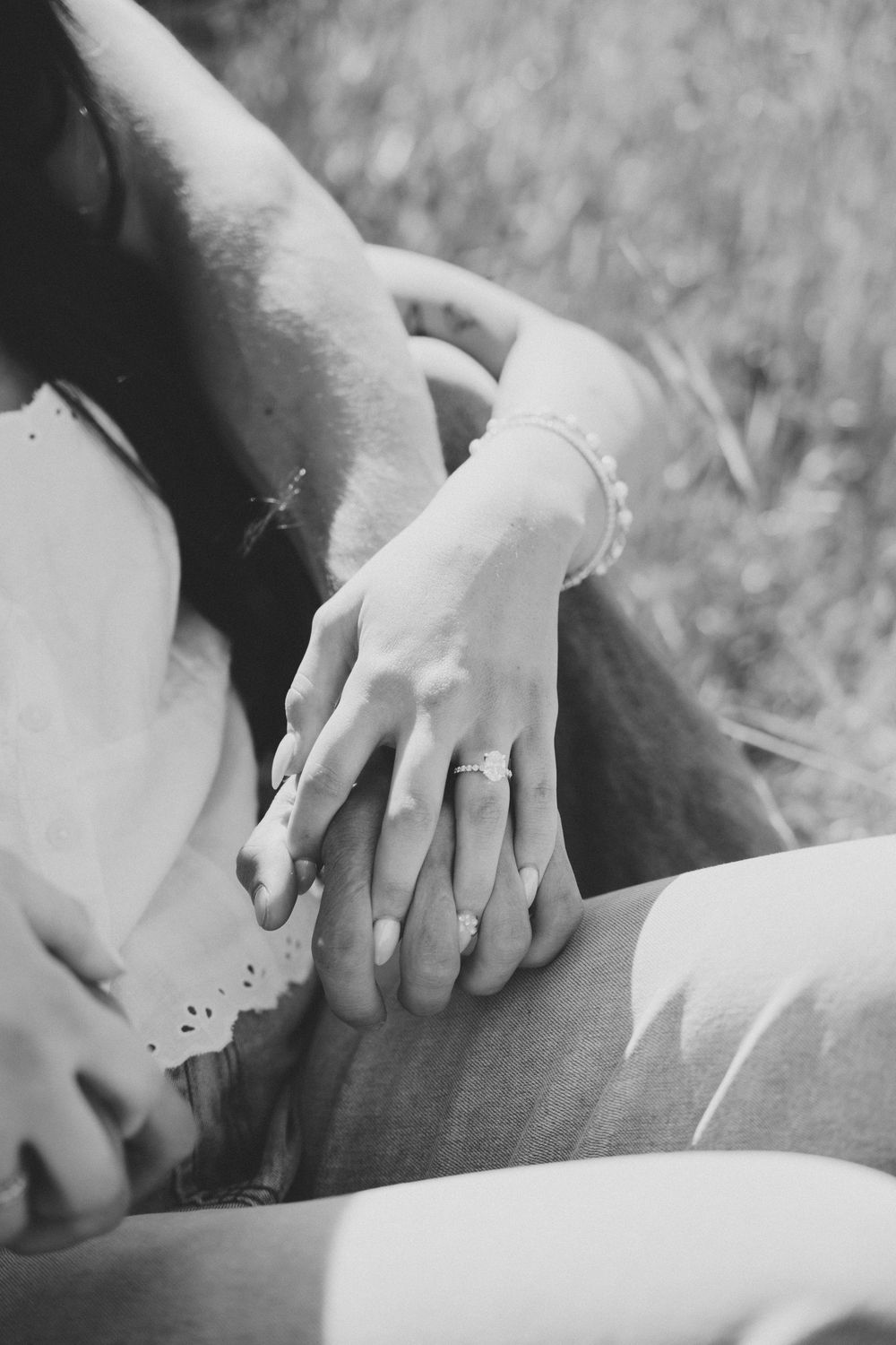 Intimate black and white portrait of couple sharing tender moment outdoors.