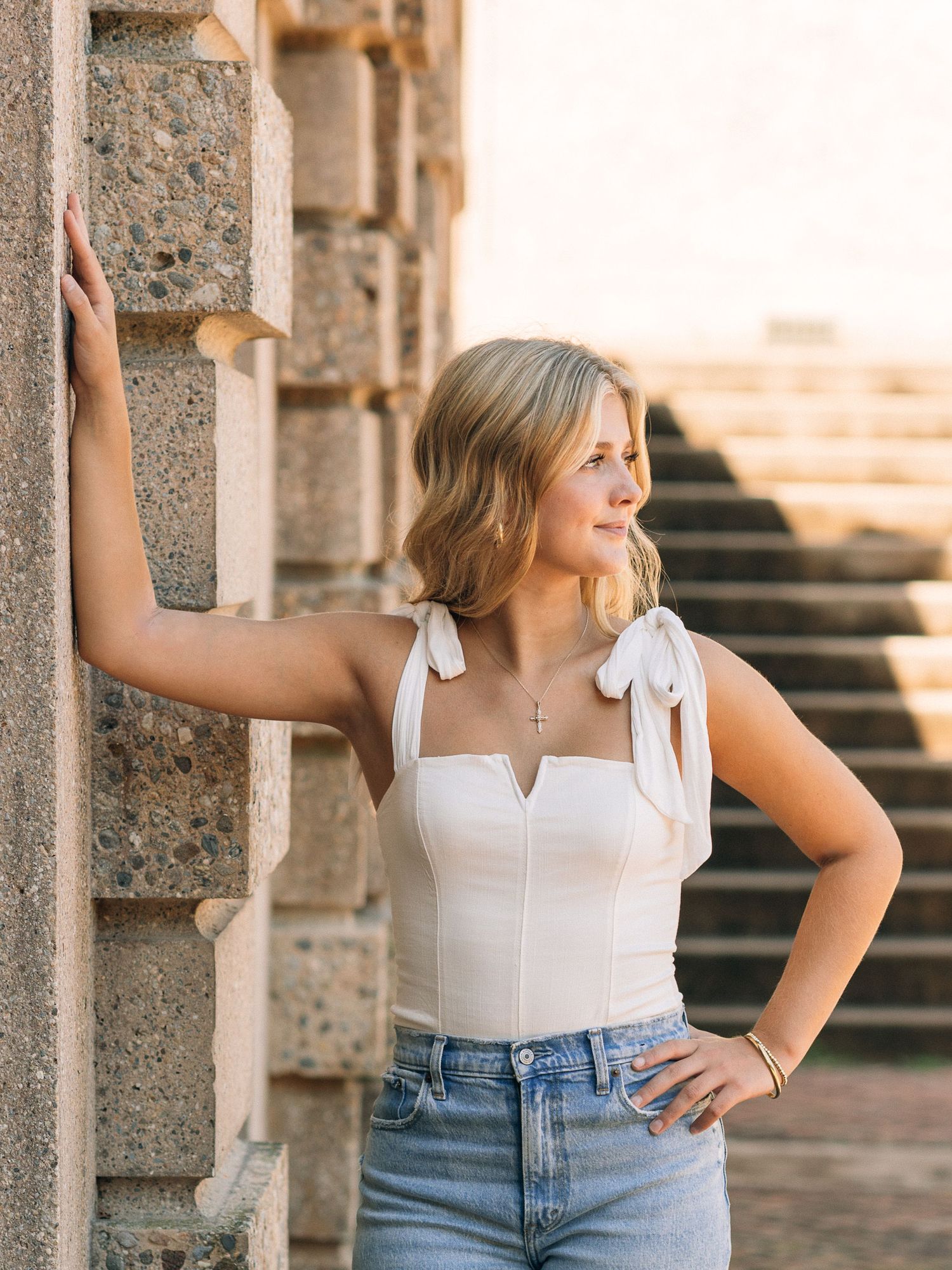 Casual summer style with white top against stone architecture.