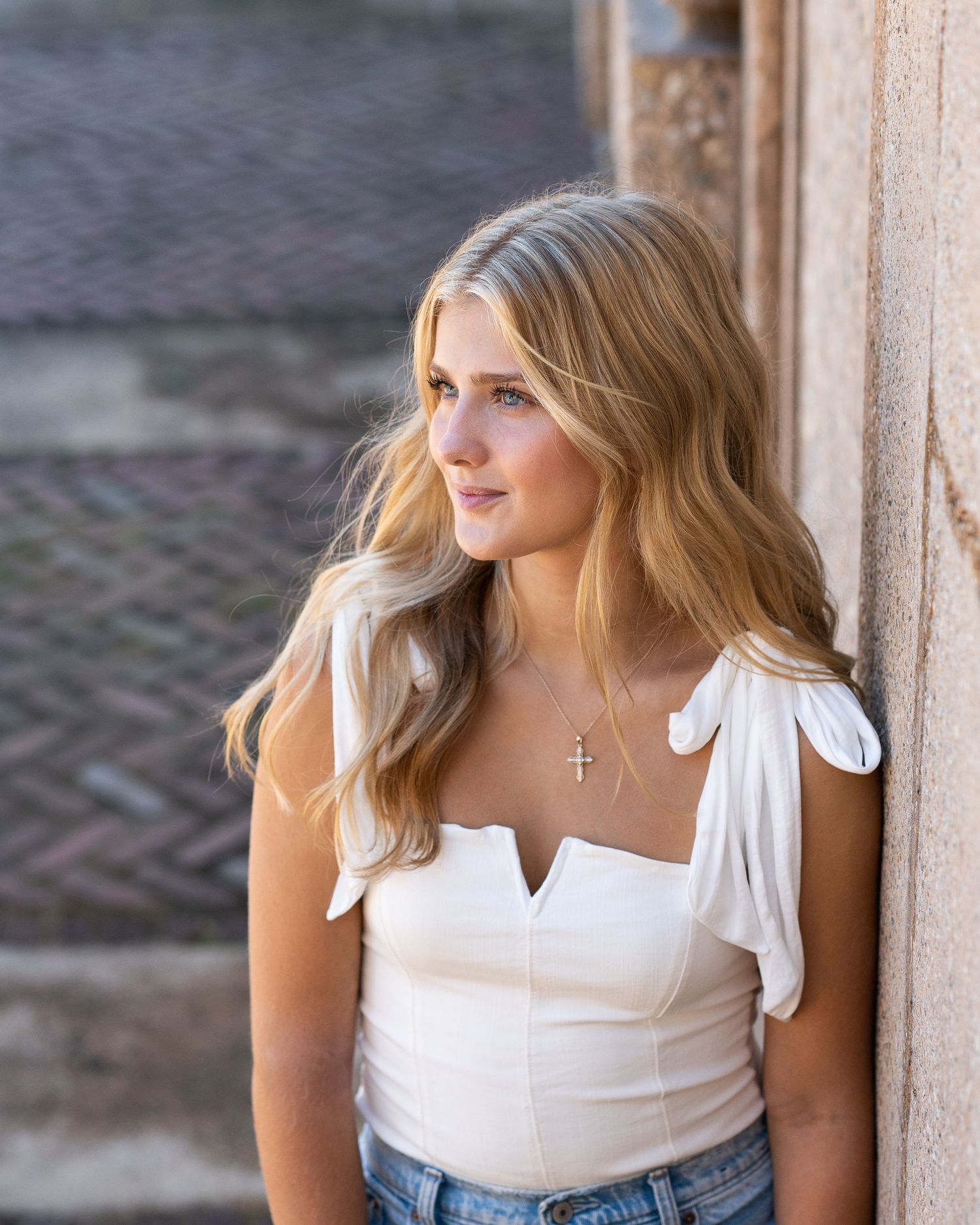 Profile portrait against stone wall in natural lighting.