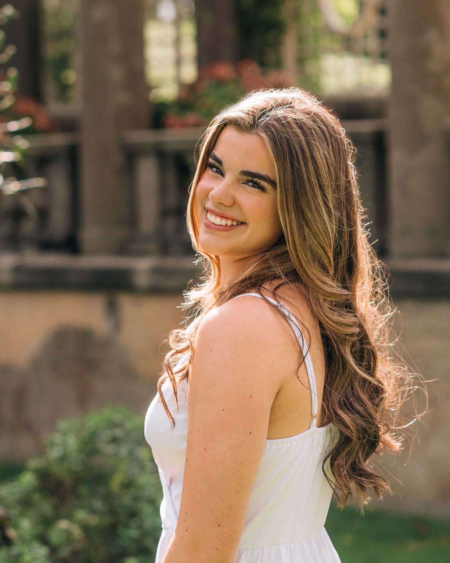Outdoor portrait with natural lighting and stone architecture backdrop.