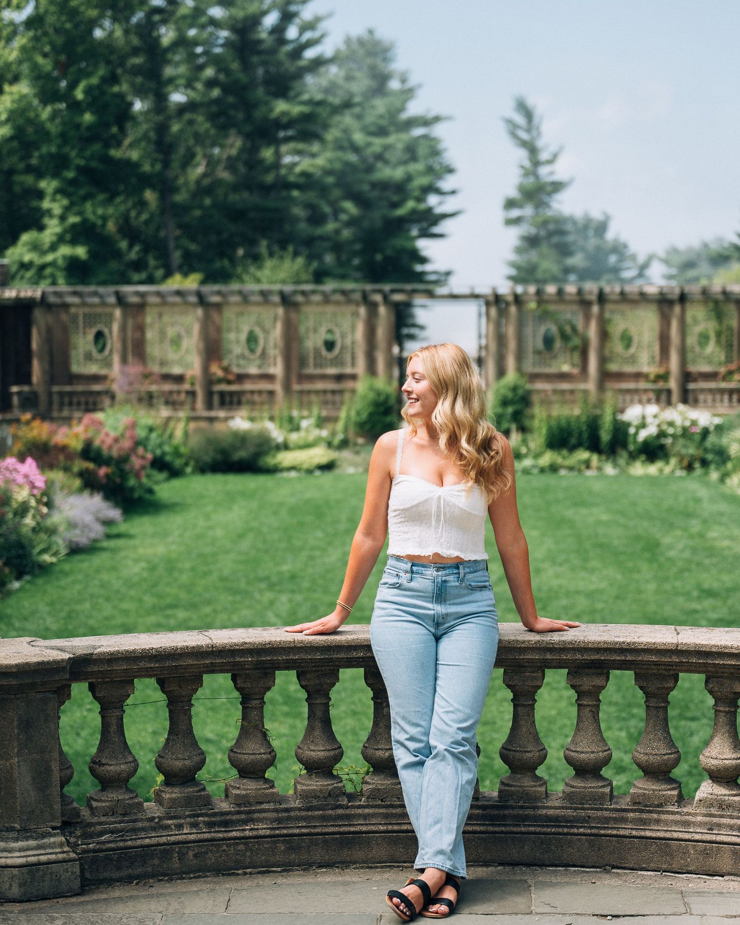 Summer garden portrait at stone balustrade with flowering plants.