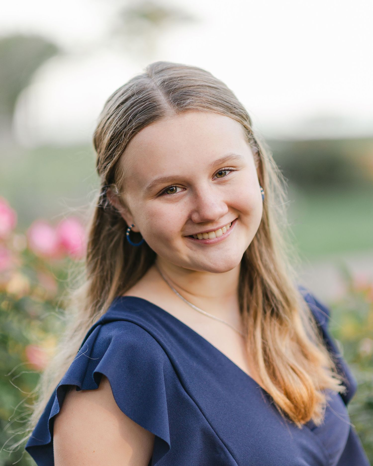 Portrait series showing warm expressions against a garden background.