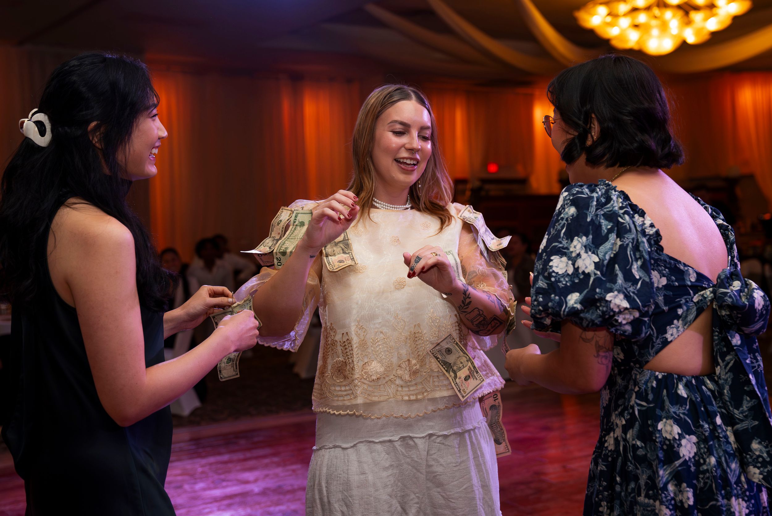 A group of women dancing and having fun at a wedding reception in an elegant ballroom.