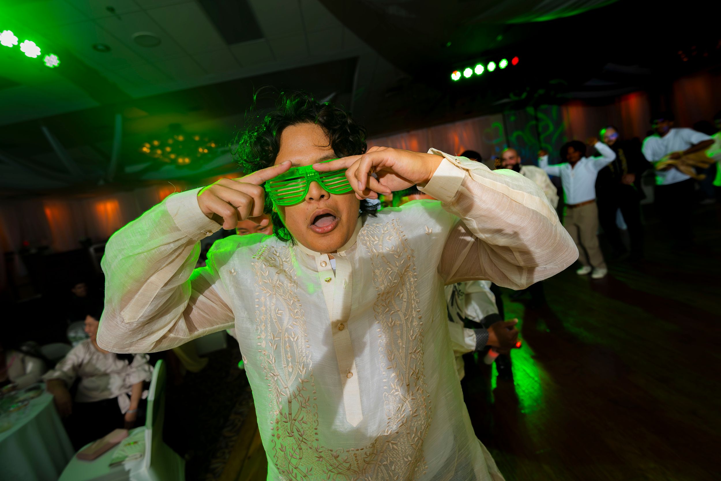 A person dancing and performing with dramatic green stage lighting creating a dynamic atmosphere at a live show.