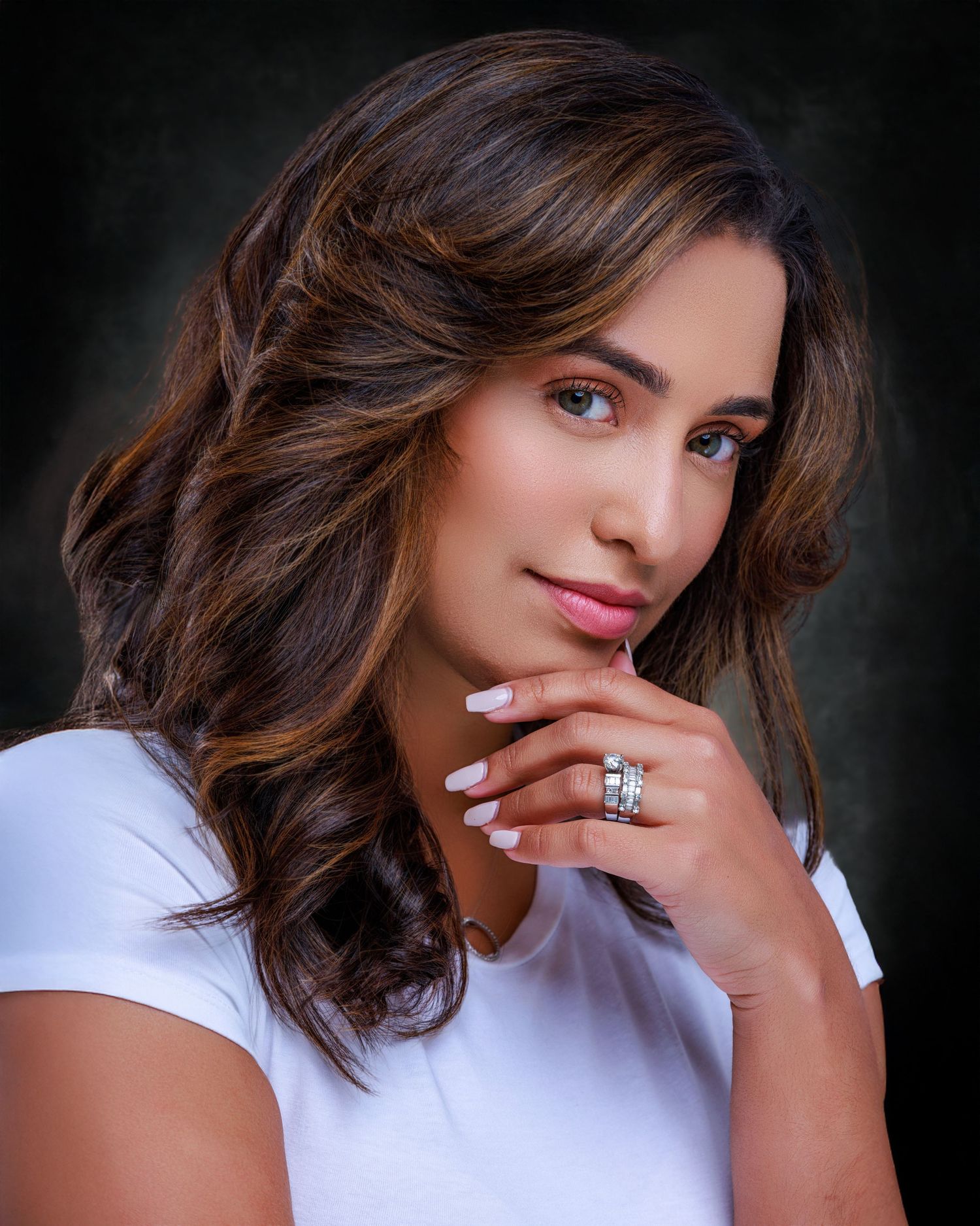 Professional headshot of a smiling woman with shoulder-length brown hair, wearing a blue blouse against a neutral background.