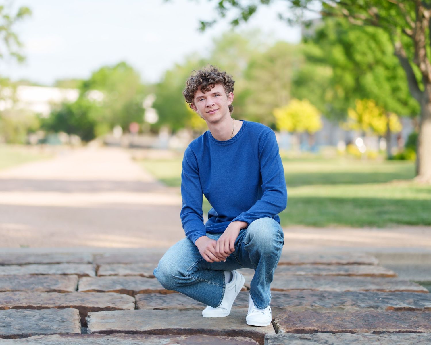 Senior photo session male wearing casual Westlake, TX senior poses cap and gown graduation tassel