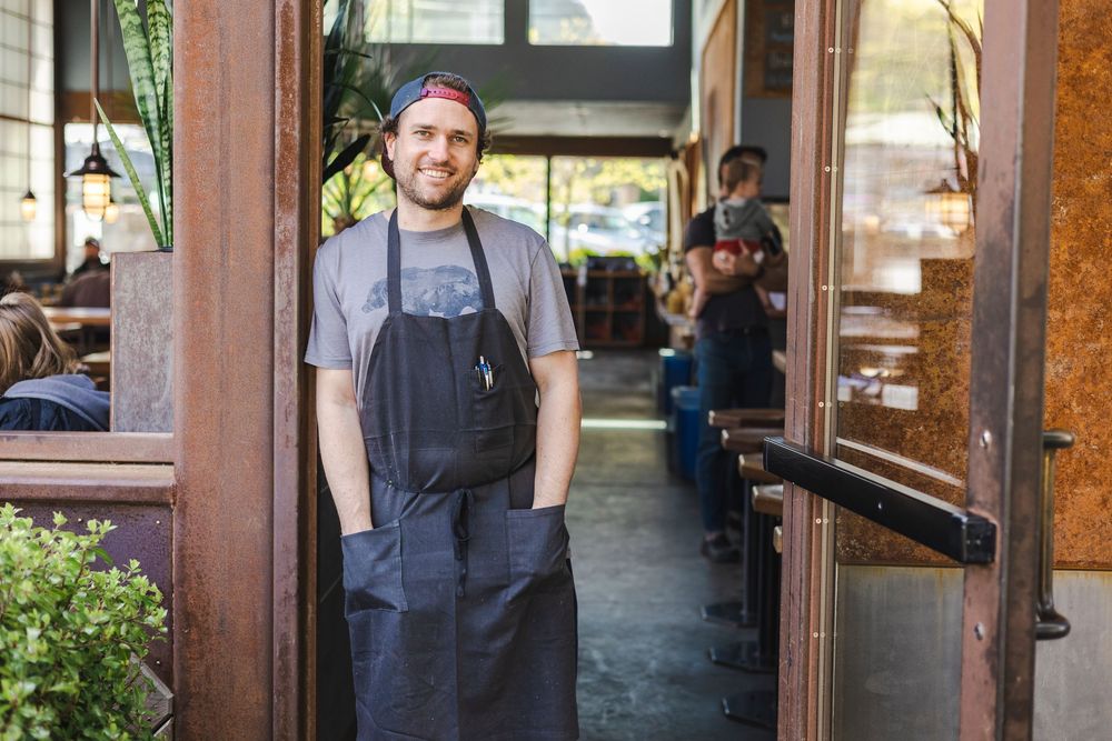 A welcoming entrance to a rustic restaurant with wooden doors and warm lighting.
