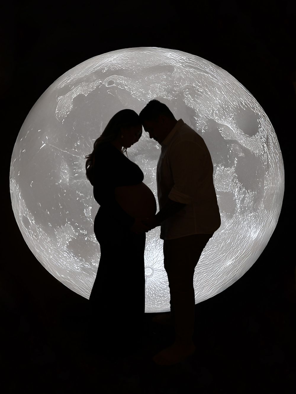 Romantic silhouette of pregnant couple against dramatic full moon backdrop.