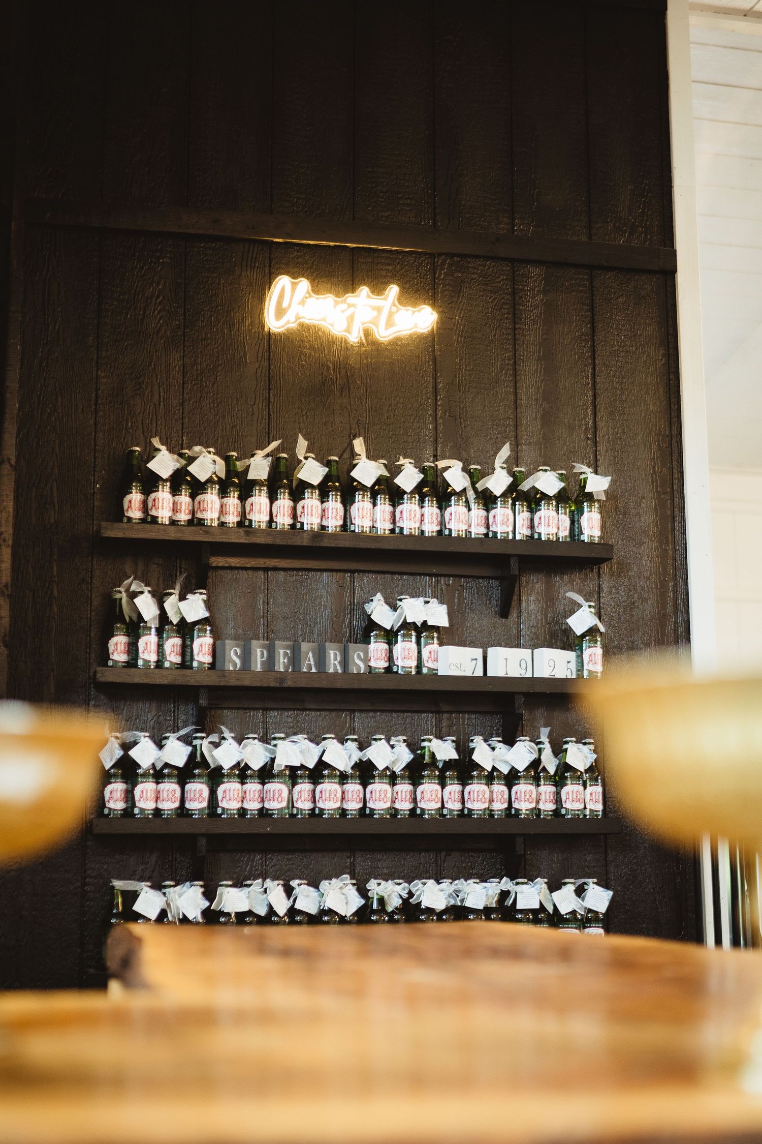 Small white paper notes arranged in rows on a dark wooden wall display panel in a dimly lit space.