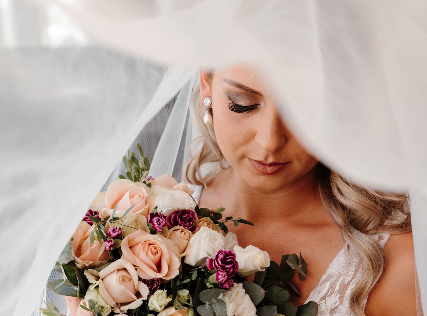 Close up wedding detail shots showing bridal bouquet with pink and burgundy flowers.