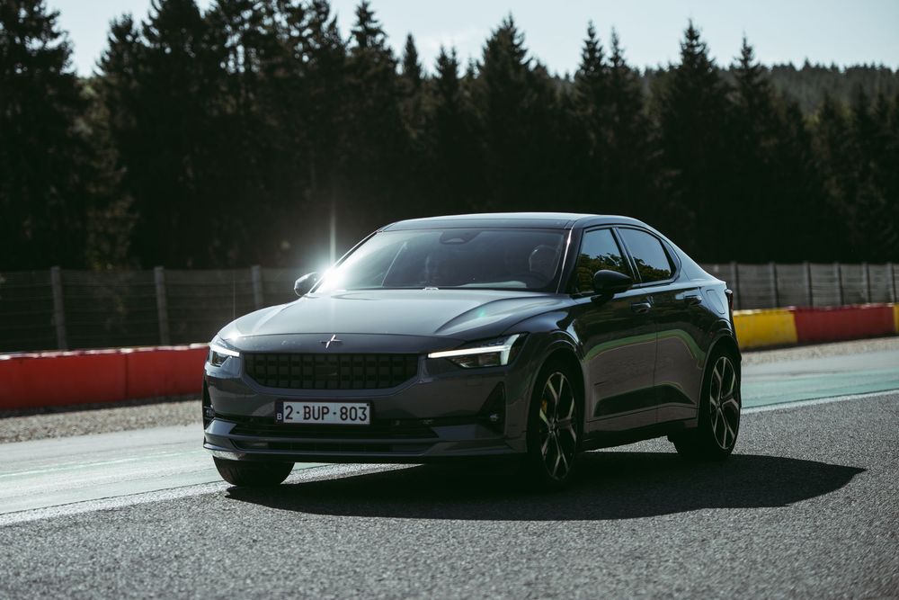 Une voiture électrique noire élégante photographiée sur un circuit automobile avec une forêt en arrière-plan. Florent Vause