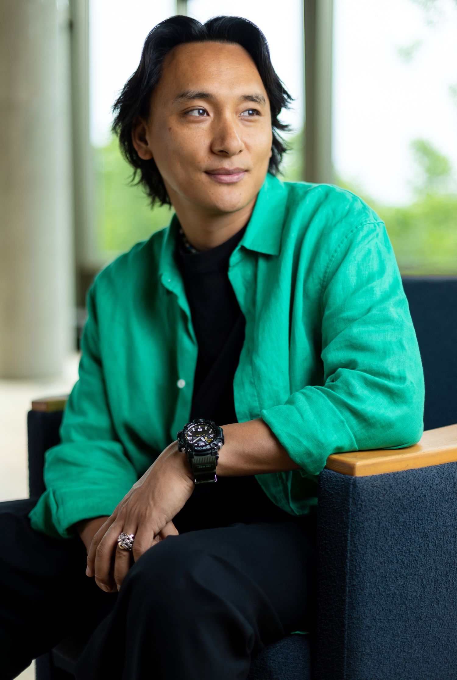 A man looks off camera while sitting for a portrait.